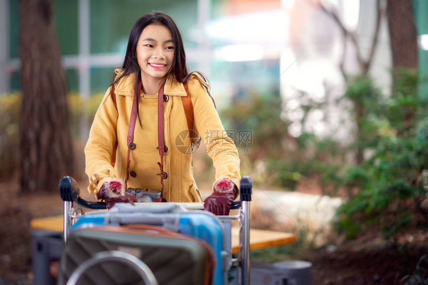 亚洲女士在国际机场携带旅行包图片