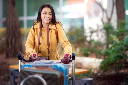 亚洲女士在国际机场携带旅行包图片