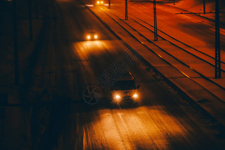 夜间在暴风雪中在湿滑的道路上行驶的救护车黑暗时期的雪道路上结冰图片