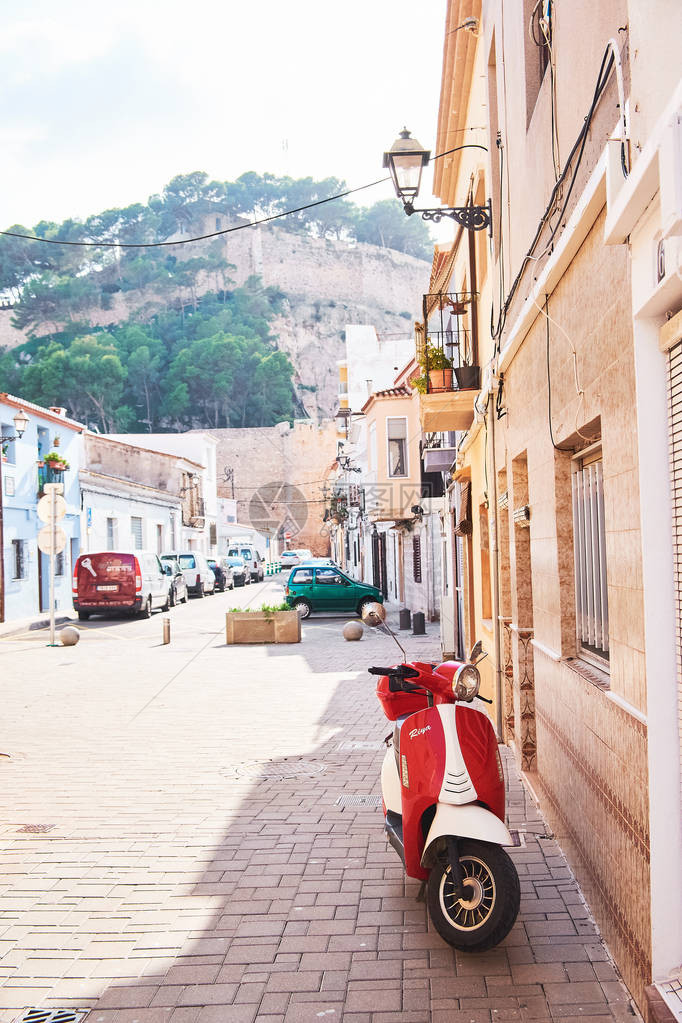 红色老车停在西班牙空荡的城街人行道上图片