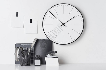 办公用品粘空白和墙上的圆形时钟图片