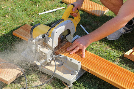 一名工人用锯子木头图片