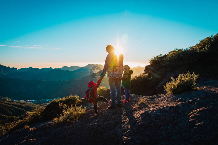 父亲和孩子一起在日落山上旅图片