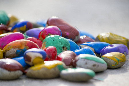 许多覆盖着五彩颜料的小鹅卵石躺在表面特写镜头上图片
