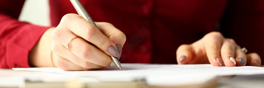 持有银笔的女职员填写一些申请表以图片