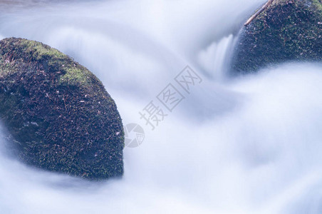 流过河流岩石的水运动模糊图片