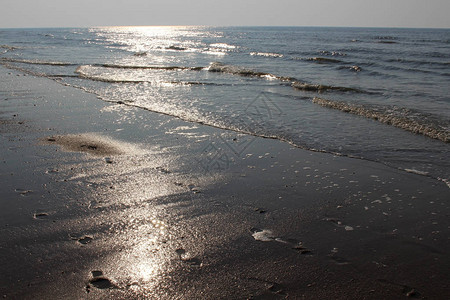 日落时北海波浪上的太阳光芒图片