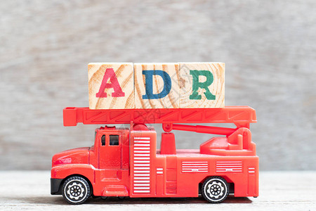 红色消防车在木材背景上用ADR减少不良药物反应图片