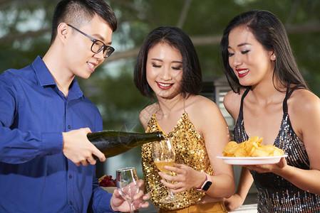盛装香槟杯的亚洲帅哥在派对上给图片
