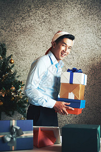 喜悦的亚洲青年企业家在圣诞老人帽子图片