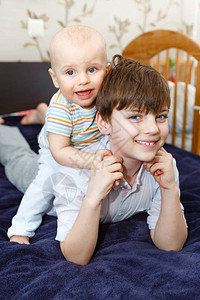 幸福家庭概念两个男孩兄弟在家室内的床图片