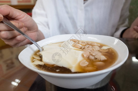 女人吃著名小吃豆腐布丁图片