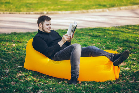 读书概念在城市公园的男人在充气床垫上图片