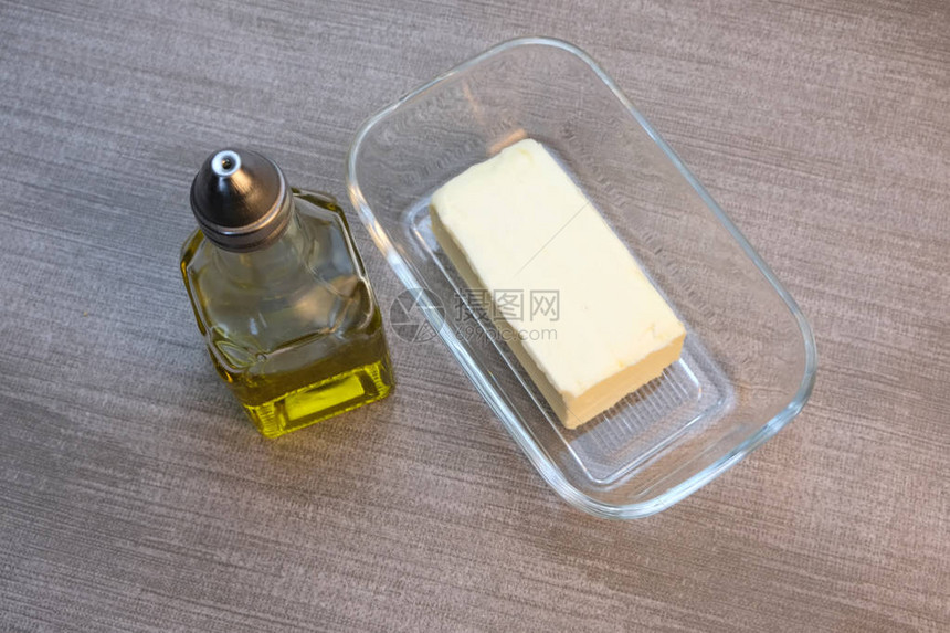 一小瓶橄榄油和玻璃餐具桌上有黄图片