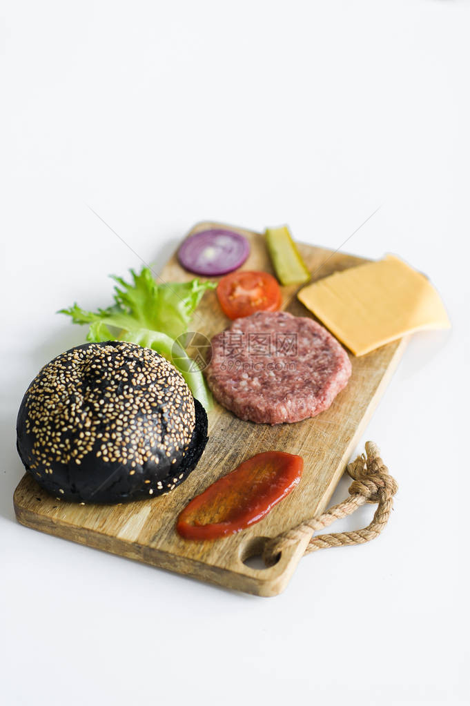 木菜板上黑汉堡的配料图片