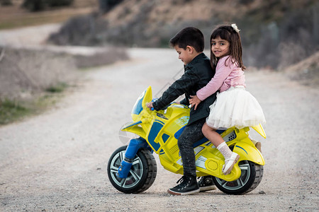 骑摩托车玩具的小男孩和女孩图片