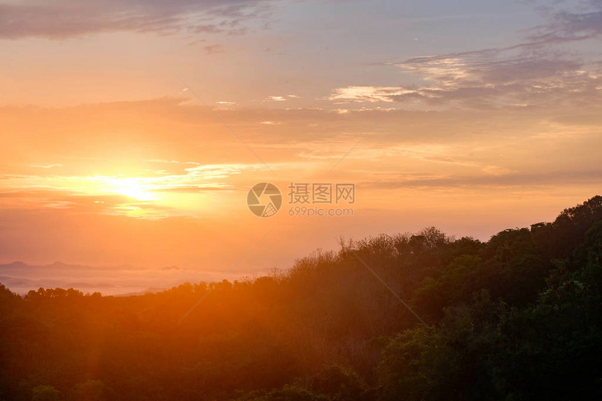 森林风景中美丽的景色日出雾山覆盖着山峰云层的阳图片