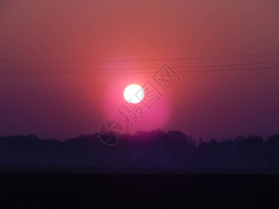 太阳在田野的黎明升起图片