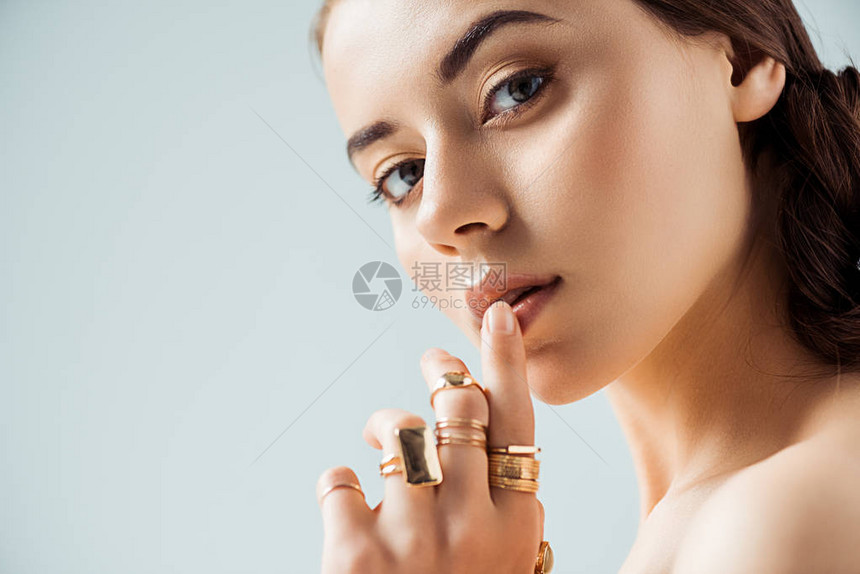 带着闪亮化妆和金环的年轻女子触摸着灰图片