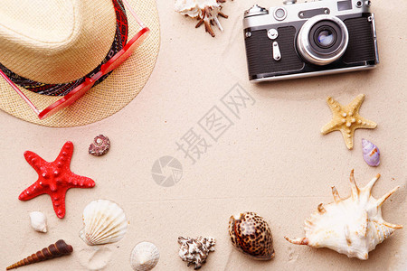 海滩配件太阳镜帽子和相机在沙子和贝壳和海星上夏季和海图片