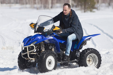 寒冷的天气一个成年男子骑着一辆蓝色大雪图片