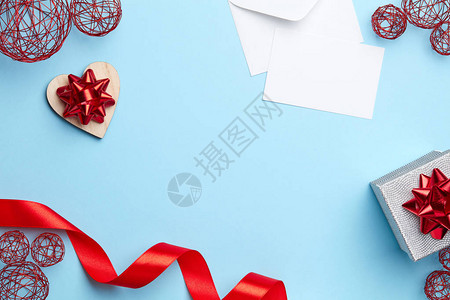 蓝色素背景银色礼物红色丝带和白色字母图片