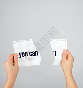 两只手握着纸撕成两半的纸刻字不能图片