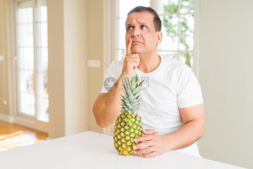 中年男人在家里吃新鲜热带菠萝图片