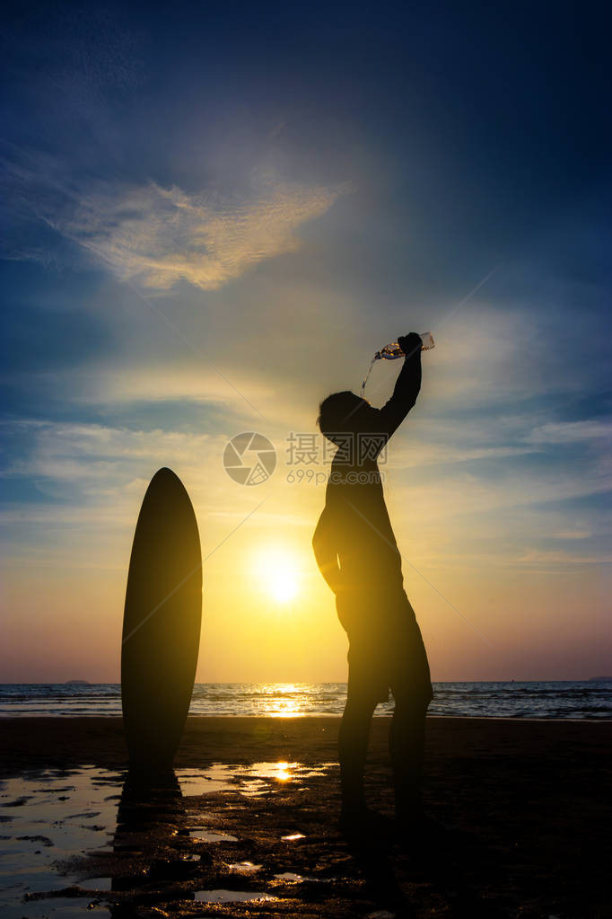 冲浪人的剪影站在冲浪板上从瓶子里喝水在日落海滩冲浪户外水上运动冒险生活方式夏季活动20多图片