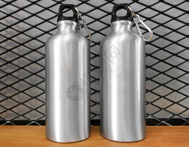 木架背景上的金属水瓶和汽水罐绝缘容器供图片