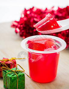 甜美的草莓果冻和木制桌上的圣诞礼物盒图片