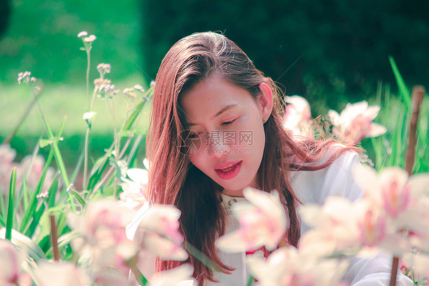 女人在看大自然中的粉红色兰花图片
