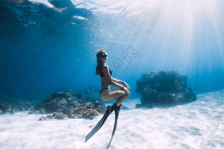 在沙滩上摆着脚蹼的女子自由潜水员在夏威夷水下自由潜水背景图片