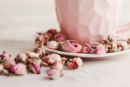 干玫瑰花蕾和粉色咖啡杯图片