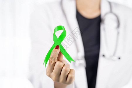 女医生用绿色丝带作为认识淋巴瘤癌症的标志图片