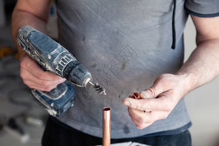 特写工人管道工大师用专业刷子清洁铜管概念安装换流水线焊锡膏专业维修图片