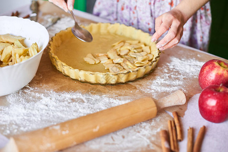 妇女用手在盘子和南瓜派的成分中修补糕点面团准备传统的甜点掌声图片