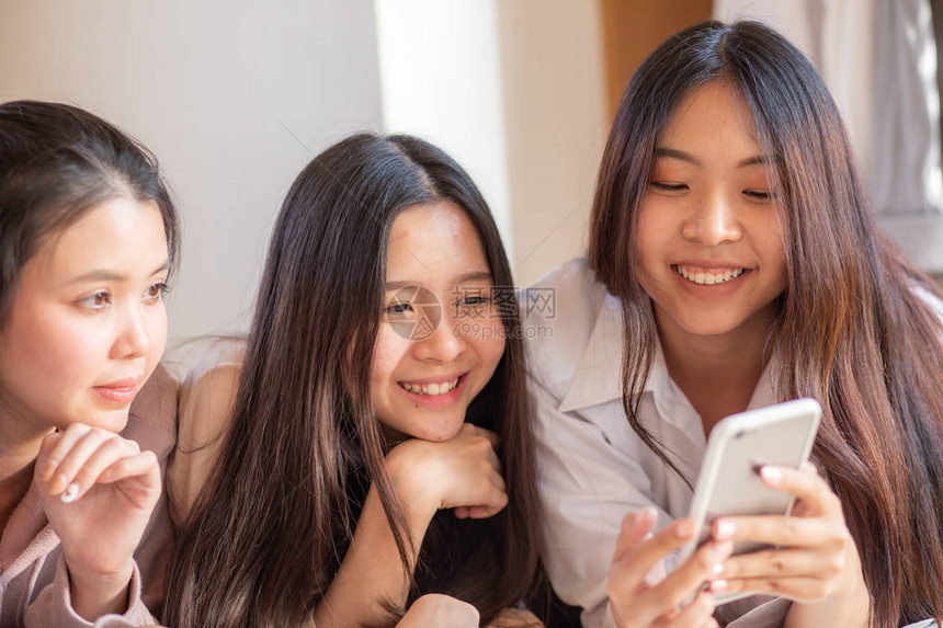 一群在家中使用智能手机上网购物的开心女群体图片
