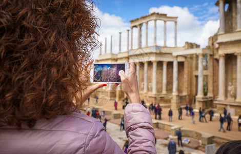 在古罗马梅里达剧院用智能手机拍照的旅游女孩图片