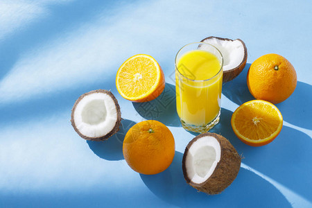 蓝色背景上的一杯橙汁橙子和椰子维生素热带夏季渴饮的概念自然光图片