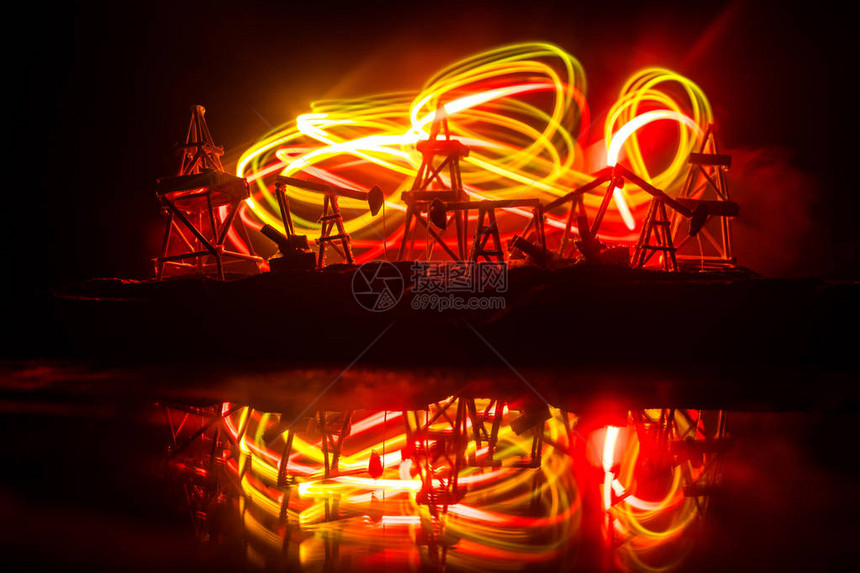 油泵和石油钻井平台在夜间为石油工业机器提供能量图片