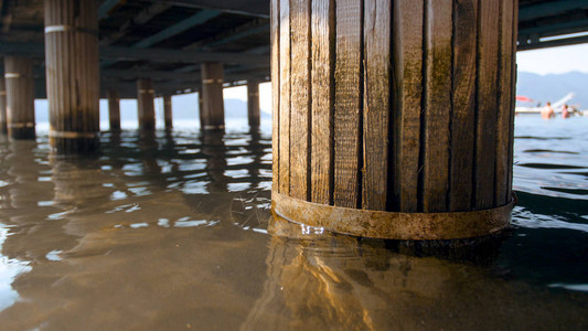 持有海上木码头的旧柱图片