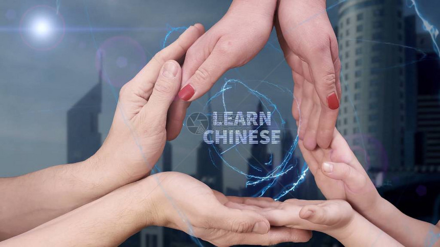 男士女士和儿童的手展示全息图学习中文这家人在一座现代城市的背景下拥图片