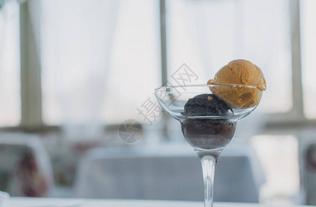 两勺冰淇淋芒果和巧克力在一个温馨的餐厅背景下一个清背景图片