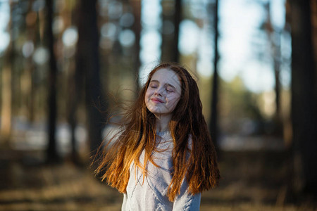 12岁可爱的小女孩长发红装扮成公园摄影机照背景图片
