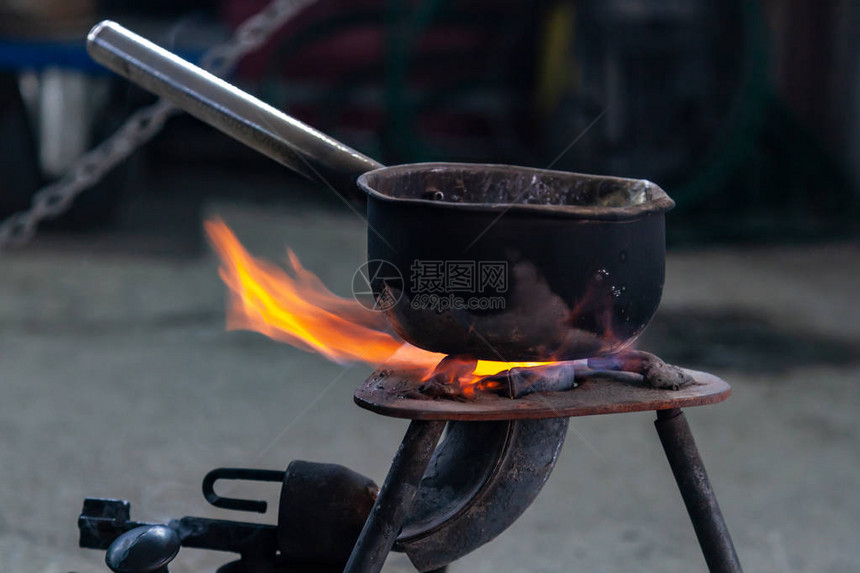 特写金属锅在铅金属冶炼车间的燃气烧器上加热旅行选择在燃气烧器的锅中烹饪食图片