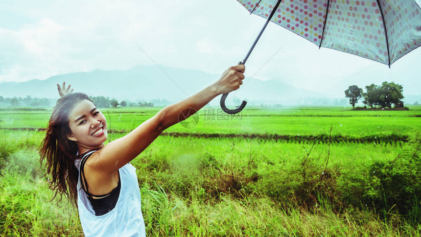 亚洲女旅行在假期放松妇女们站在雨伞里在雨季期间的图片