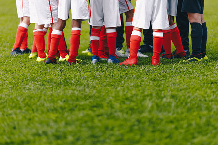 少年足球队站在小组中足球草地和球员脚足球场草背景在学校的足球场年轻的足球运动员背景图片