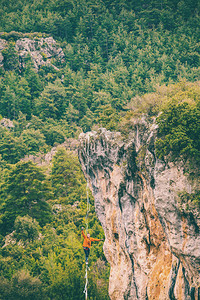 一个人正沿着一条拉长的吊索行走山中的高线人抓住平衡走钢丝者在大自然中的表现Highliner在背景图片