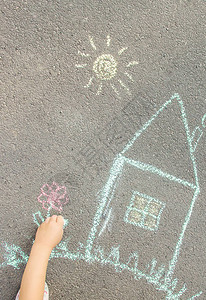 孩子用沥青上粉笔画房子有选择的焦点图片